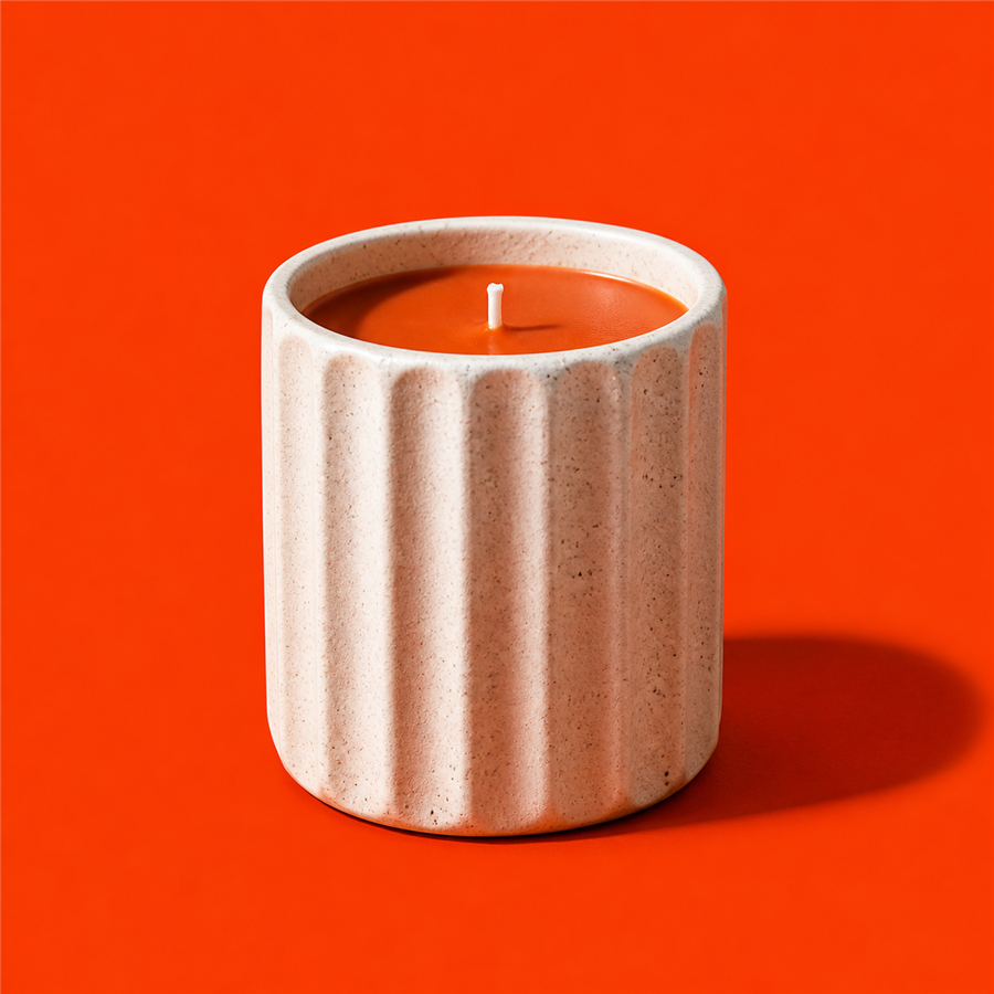 Ember scented candle in a fluted ivory ceramic vessel with orange wax